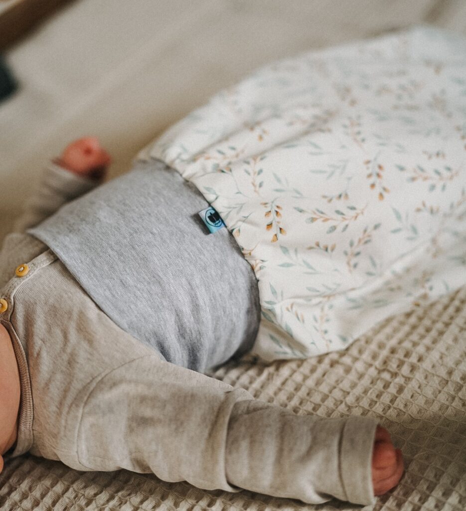 Ein Baby schläft in einem Strampelsack von Tulipanelli