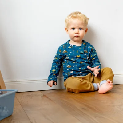 Junge trägt Longshirt mit Baustellen-Print und eine kuschelige Hose aus Alpenfleece