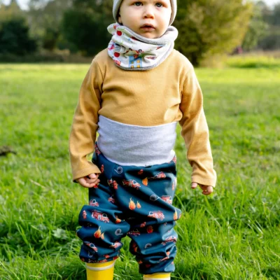 Kleinkind in handgefertigter Softshell-Hose mit Loop und Beanie-Mütze
